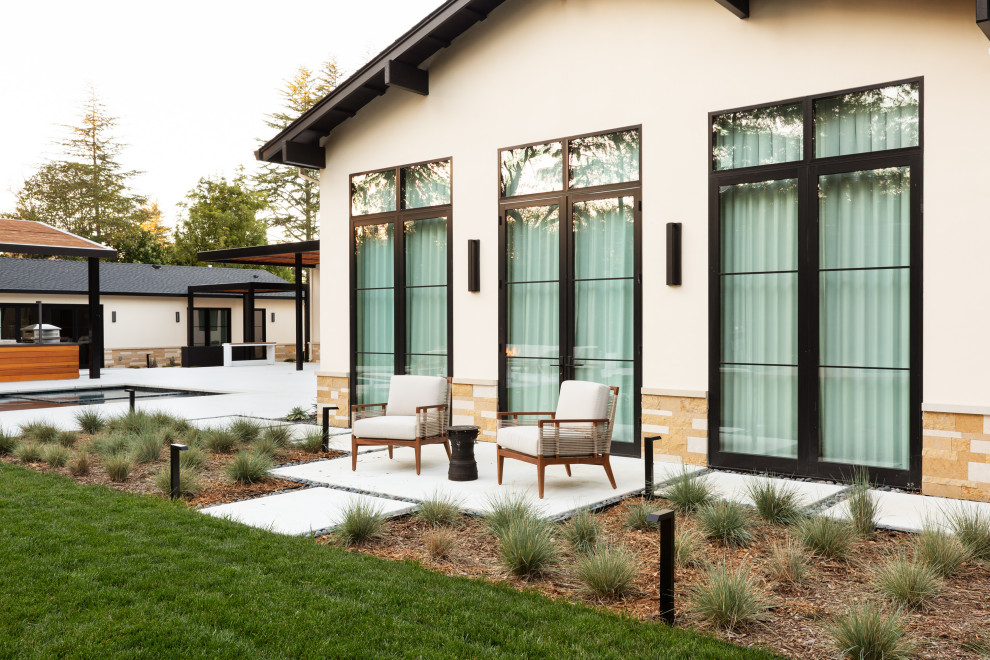 Esempio di un ampio giardino xeriscape minimalista esposto in pieno sole dietro casa in primavera con un focolare, graniglia di granito e recinzione in legno