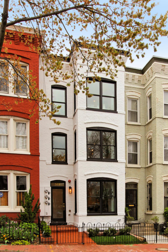 Photo of a large traditional three-storey brick white apartment exterior in DC Metro with a flat roof.