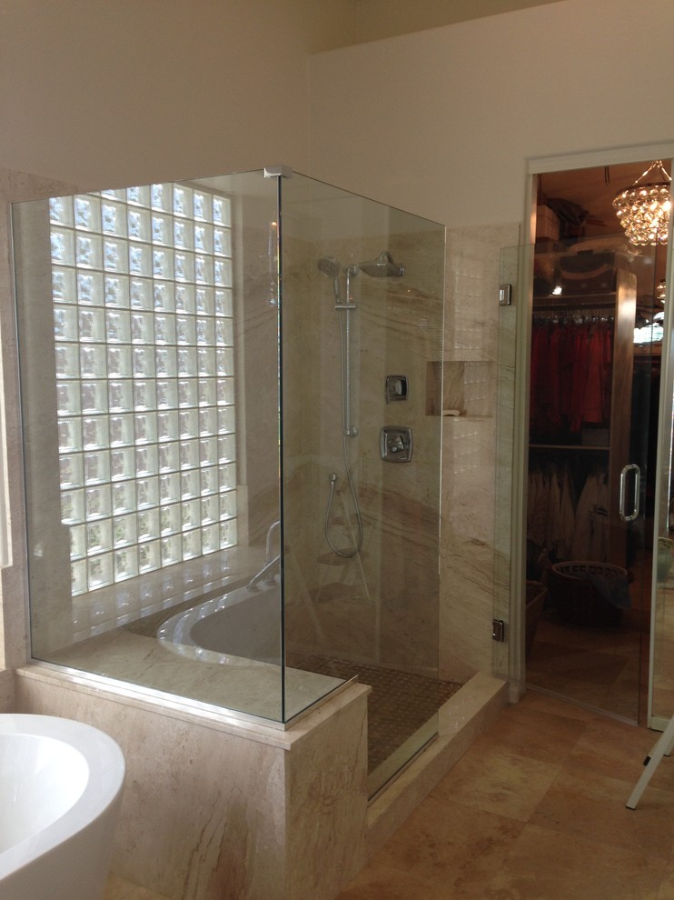 Photo of a mid-sized traditional master bathroom in Phoenix with a freestanding tub, a corner shower, beige tile, limestone, beige walls, limestone floors, limestone benchtops, beige floor, a hinged shower door and a two-piece toilet.
