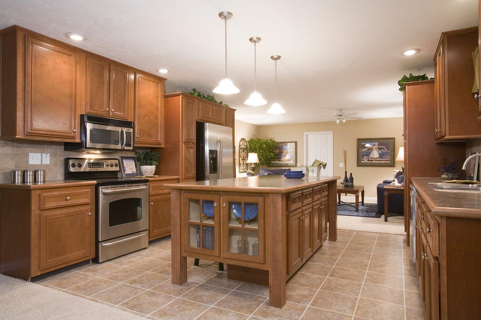 Mid-sized elegant ceramic tile eat-in kitchen photo in Detroit with a double-bowl sink, raised-panel cabinets, medium tone wood cabinets, laminate countertops, beige backsplash, ceramic backsplash, stainless steel appliances and an island