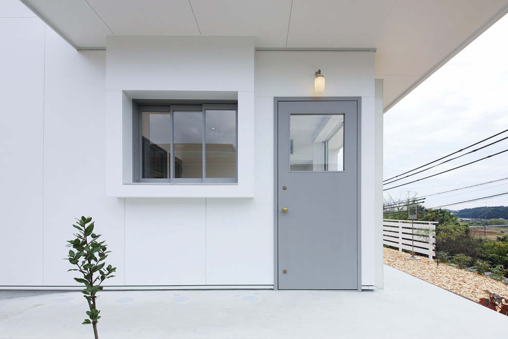 Photo of a modern front door in Other with white walls, a sliding front door, a grey front door, grey floors and a wallpapered ceiling.