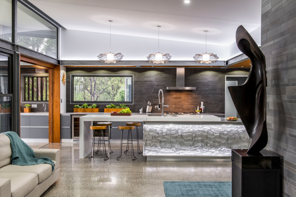 This is an example of an expansive contemporary galley kitchen pantry in Brisbane with a double-bowl sink, flat-panel cabinets, grey cabinets, grey splashback, ceramic splashback, stainless steel appliances, concrete floors and multiple islands.