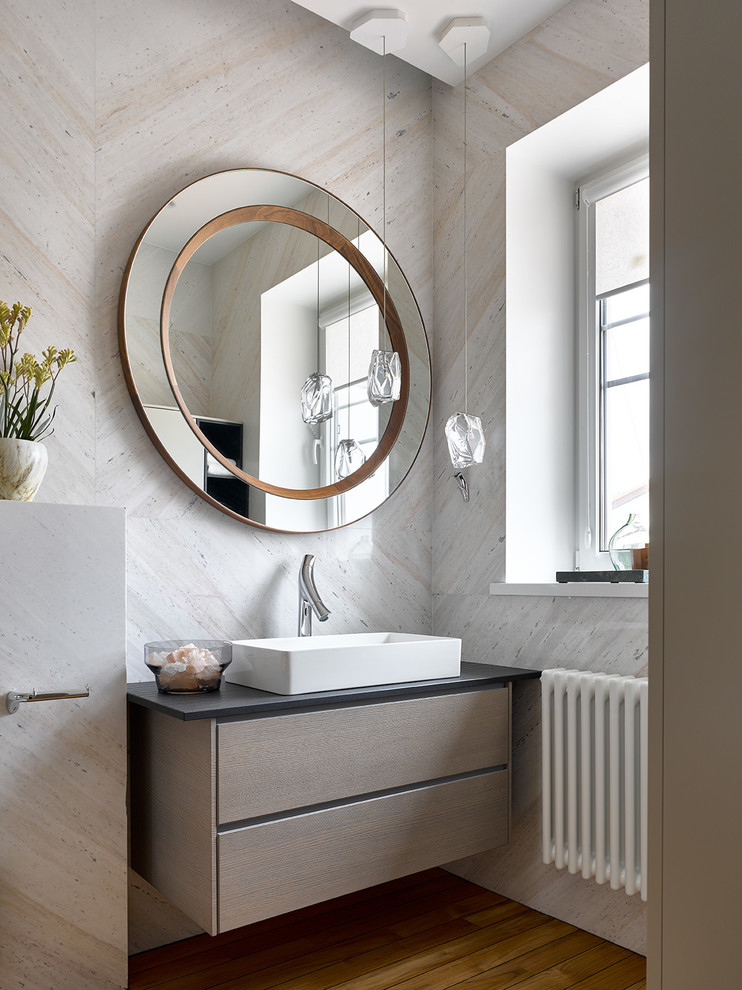 Mid-sized contemporary bathroom in Moscow with flat-panel cabinets, gray tile, marble, quartzite benchtops, black benchtops, a vessel sink, brown floor, brown cabinets and medium hardwood floors.