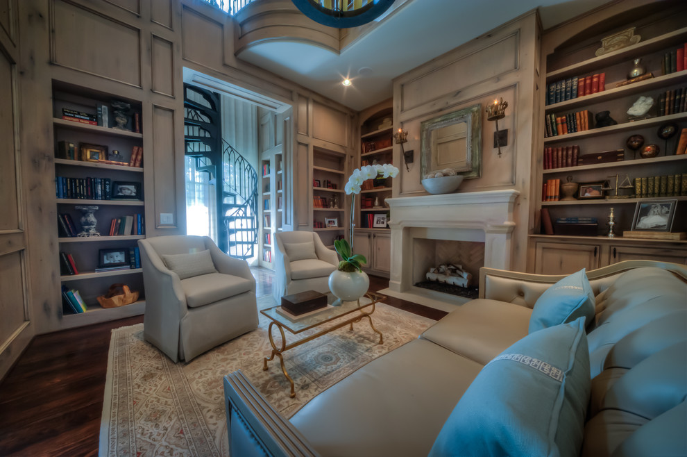 Home office library - large traditional dark wood floor and brown floor home office library idea in Houston with beige walls, a standard fireplace and a plaster fireplace
