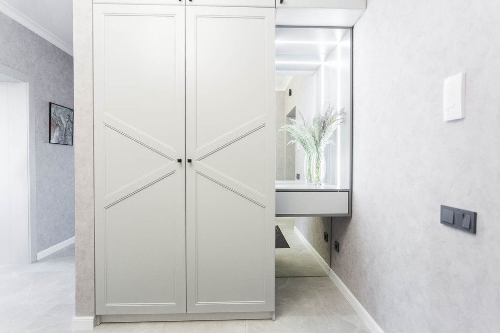 На фото: узкая прихожая среднего размера в стиле неоклассика (современная классика) с серыми стенами, полом из керамической плитки, одностворчатой входной дверью и обоями на стенах с