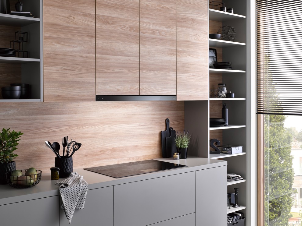 Inspiration for a contemporary kitchen in Other with flat-panel cabinets, grey cabinets, brown splashback, timber splashback, black appliances and grey benchtop.
