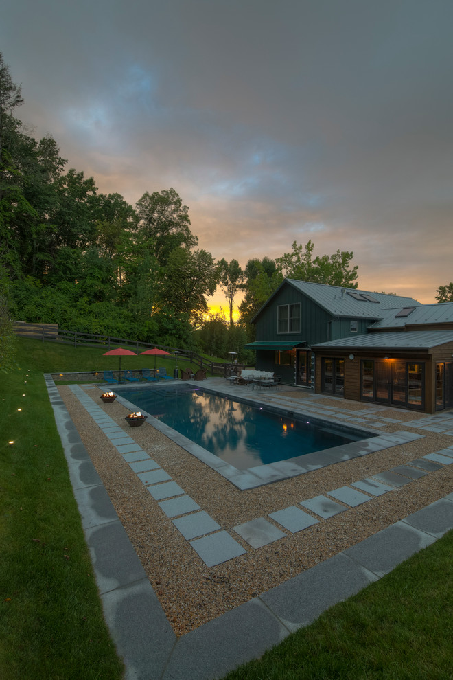 Example of a mid-sized mountain style backyard stone and rectangular lap pool design in New York