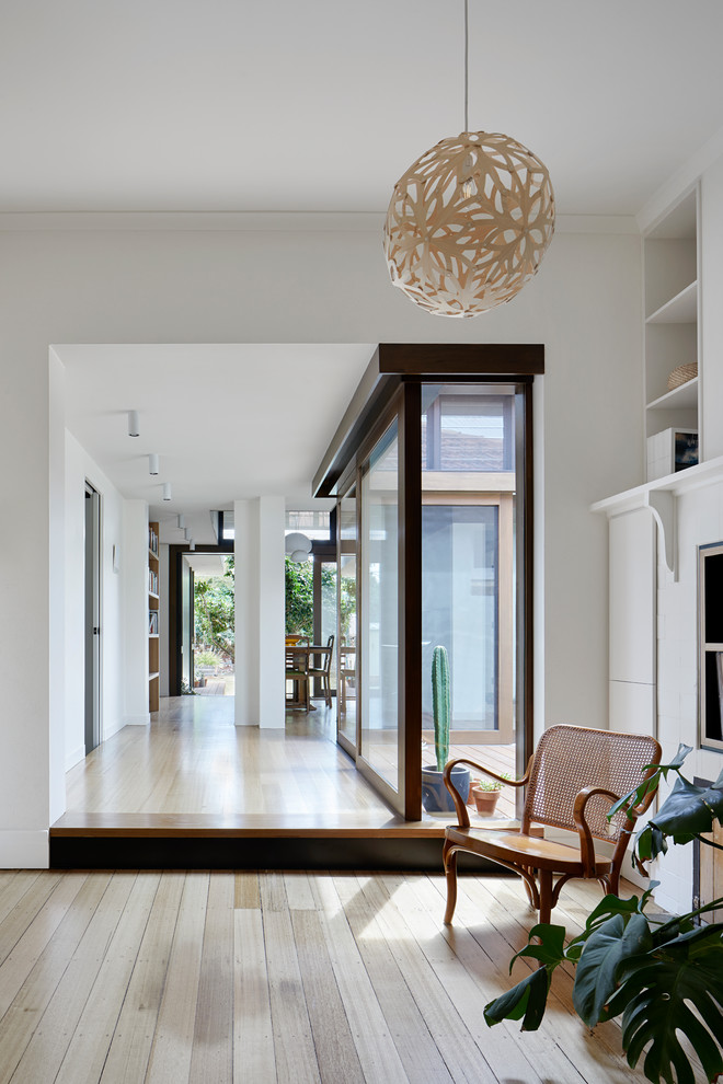 Mid-sized contemporary hallway in Melbourne with white walls and medium hardwood floors.