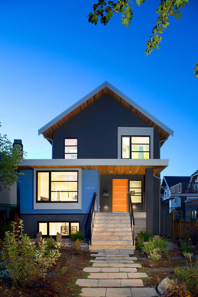 This is an example of a mid-sized transitional two-storey blue exterior in Vancouver.