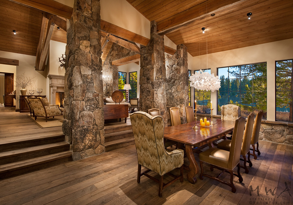 Large country open plan dining in Other with beige walls, dark hardwood floors, a standard fireplace and brown floor.