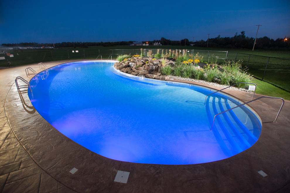 Example of a huge mountain style courtyard stamped concrete and freeform natural pool fountain design
