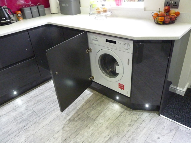 Gloss lacquered 'graphite' handleless kitchen with white quartz worktops contemporaneo-cocina