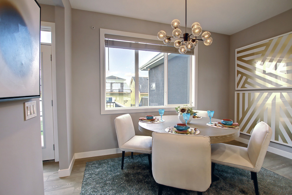 Immagine di una sala da pranzo aperta verso il soggiorno tradizionale con pareti grigie, parquet chiaro e pavimento marrone