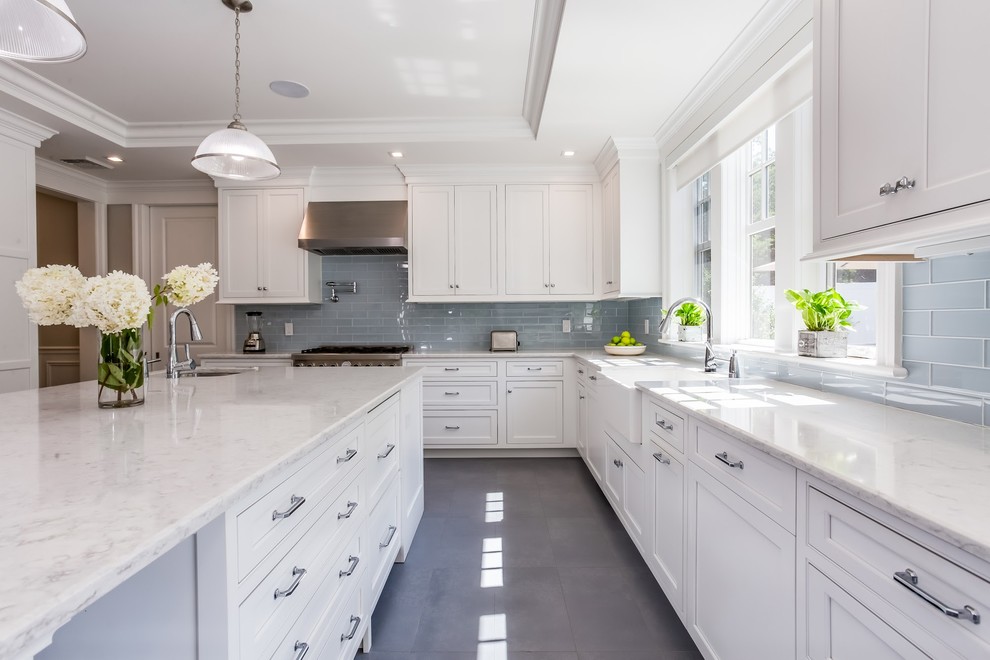 This is an example of a mid-sized transitional eat-in kitchen in Atlanta with an undermount sink, shaker cabinets, white cabinets, quartzite benchtops, grey splashback, glass tile splashback, stainless steel appliances, with island, grey floor, white benchtop and cement tiles.