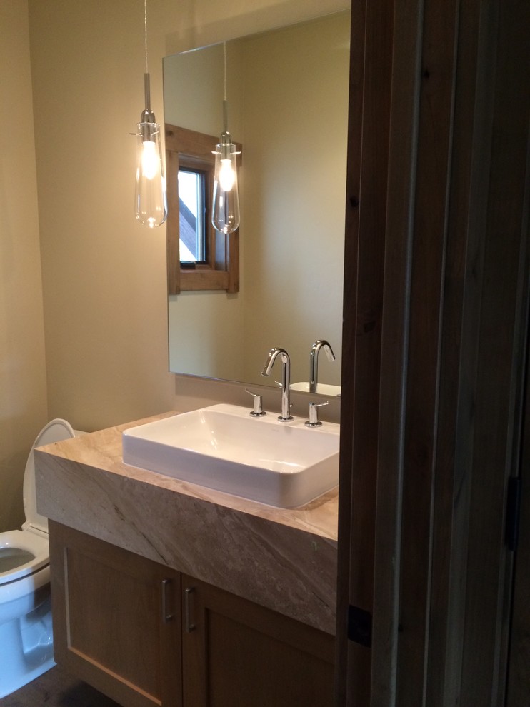 Example of a small transitional bathroom design with a vessel sink, medium tone wood cabinets and granite countertops
