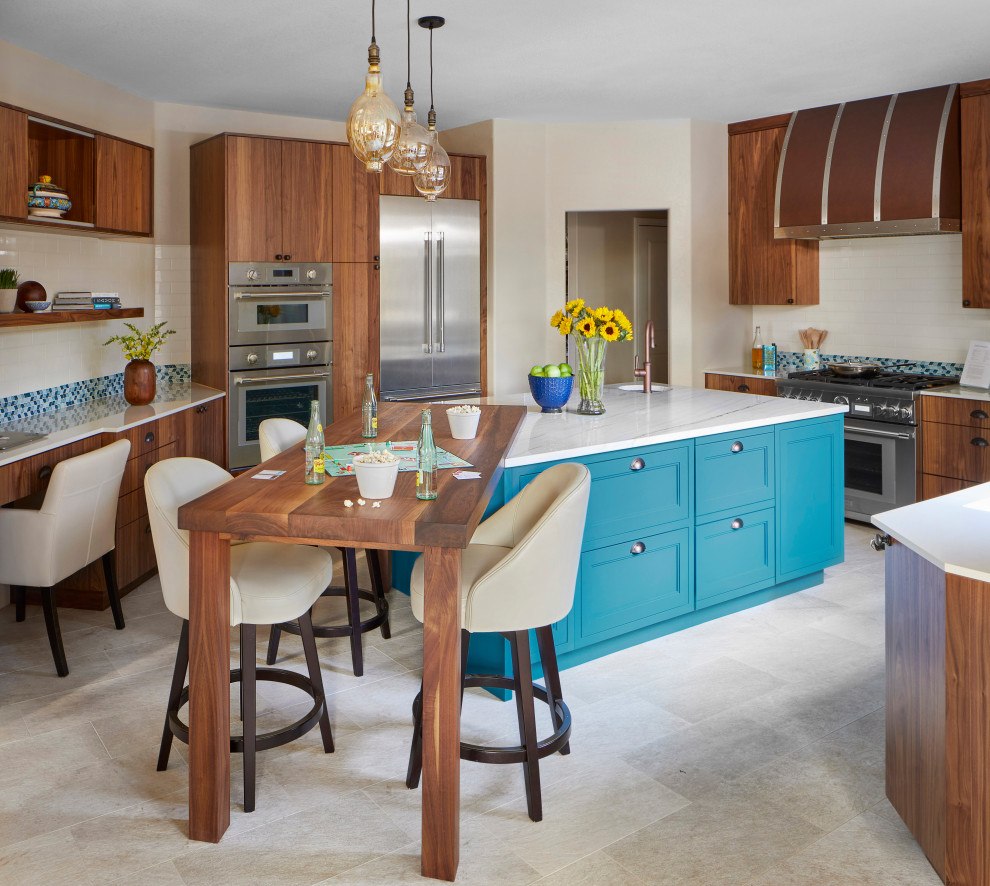 Inspiration for a mid-sized tropical u-shaped eat-in kitchen in Denver with flat-panel cabinets, medium wood cabinets, quartzite benchtops, ceramic splashback, stainless steel appliances, porcelain floors, with island, white benchtop, an undermount sink, blue splashback and grey floor.