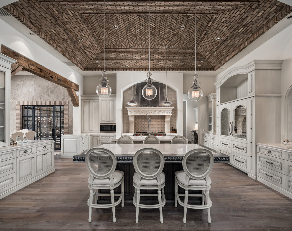 Enclosed kitchen - huge rustic u-shaped dark wood floor and brown floor enclosed kitchen idea in Phoenix with a farmhouse sink, raised-panel cabinets, light wood cabinets, marble countertops, multicolored backsplash, subway tile backsplash, stainless steel appliances, two islands and multicolored countertops