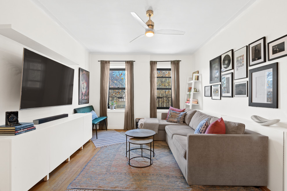 This is an example of a mid-sized eclectic open concept living room in New York with a wall-mounted tv.