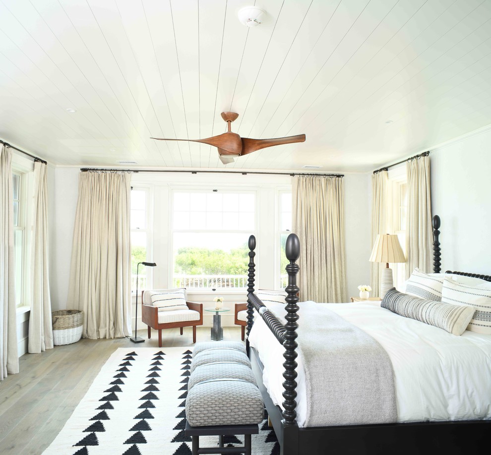 Photo of a beach style master bedroom in Charleston with white walls, no fireplace and dark hardwood floors.