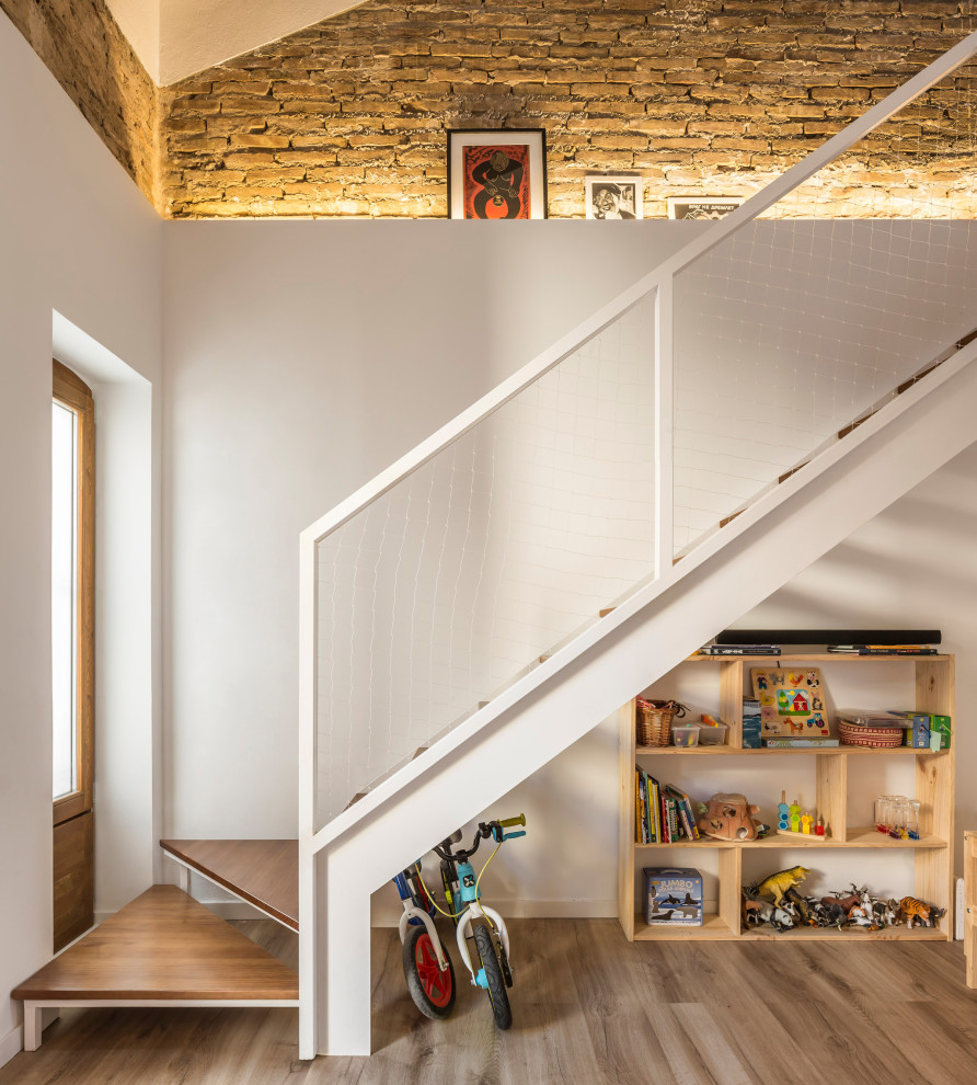 Design ideas for a small mediterranean wood straight staircase in Valencia with open risers, mixed railing and brick walls.
