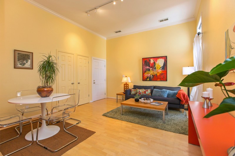 Mid-sized contemporary formal enclosed living room in San Francisco with yellow walls, light hardwood floors and no tv.