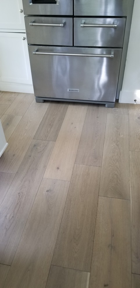 Photo of a modern kitchen in San Francisco with shaker cabinets, white cabinets, light hardwood floors and beige floor.