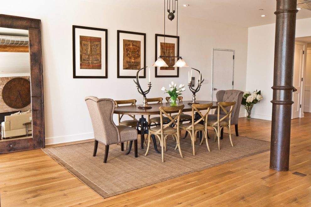 Design ideas for a large industrial open plan dining room in New York with white walls and medium hardwood flooring.