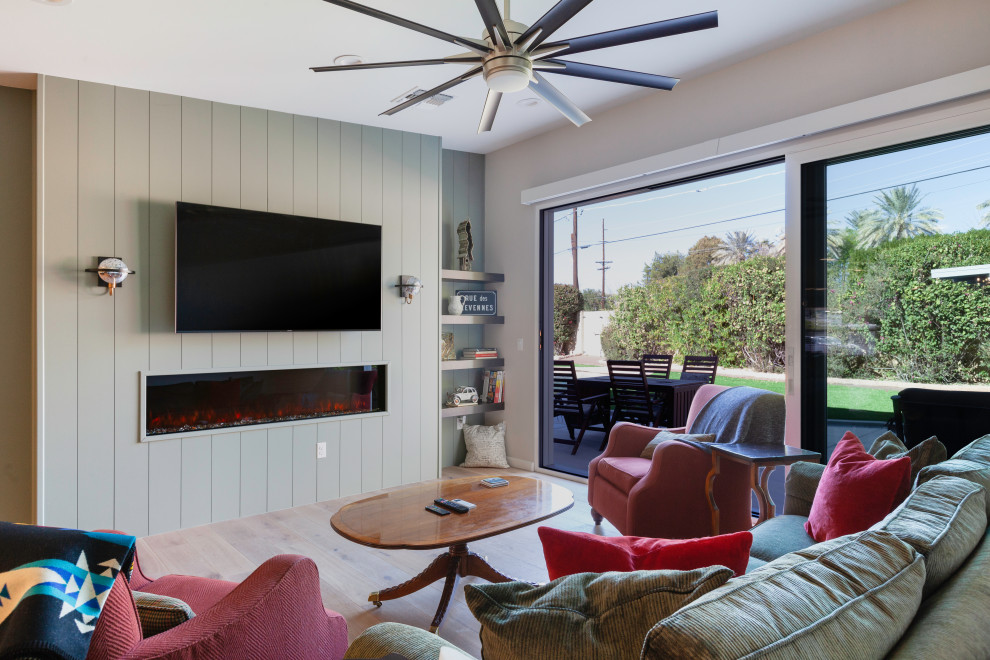 Пример оригинального дизайна: открытая гостиная комната в стиле ретро с фасадом камина из вагонки и телевизором на стене