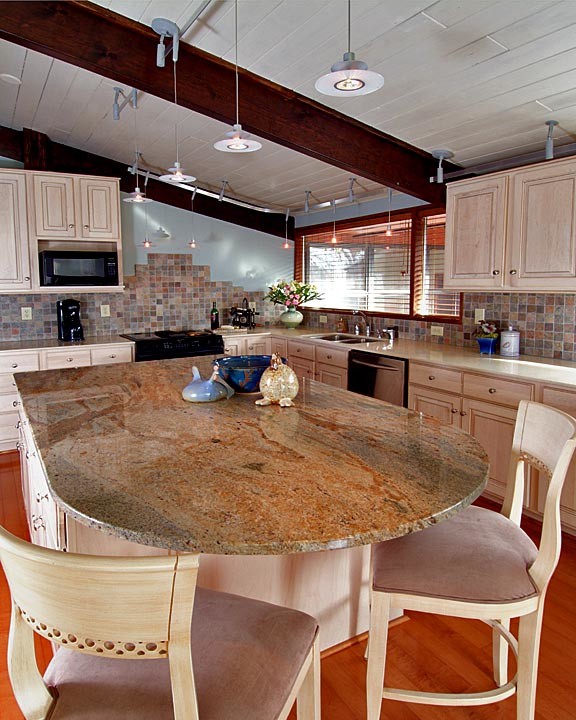 Mid-sized transitional l-shaped medium tone wood floor open concept kitchen photo in Charlotte with a double-bowl sink, raised-panel cabinets, light wood cabinets, granite countertops, multicolored backsplash, porcelain backsplash, stainless steel appliances and an island