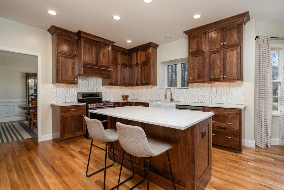 Mid-sized transitional u-shaped medium tone wood floor eat-in kitchen photo with a farmhouse sink, beaded inset cabinets, medium tone wood cabinets, white backsplash, stainless steel appliances and an island