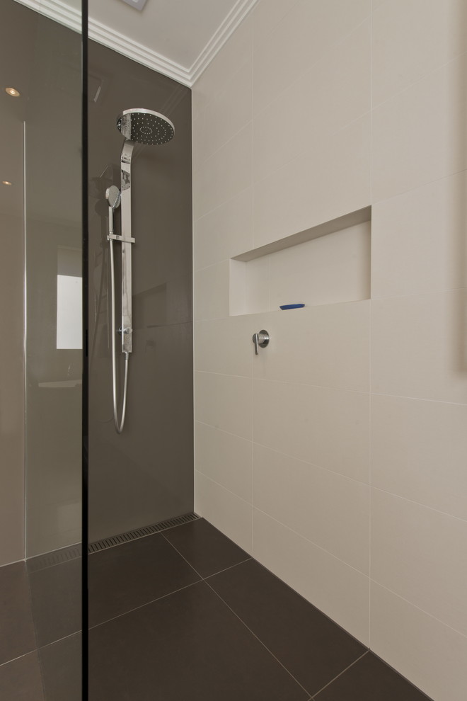 Design ideas for a mid-sized modern bathroom in Melbourne with flat-panel cabinets, black cabinets, a freestanding tub, an open shower, a wall-mount toilet, multi-coloured tile, porcelain tile, white walls, porcelain floors, an integrated sink, solid surface benchtops, grey floor and an open shower.