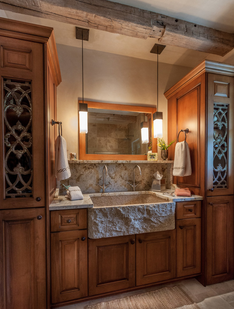 This is an example of a mid-sized arts and crafts master bathroom in Denver with raised-panel cabinets, medium wood cabinets, beige walls, a one-piece toilet, beige tile, slate floors, an integrated sink and granite benchtops.