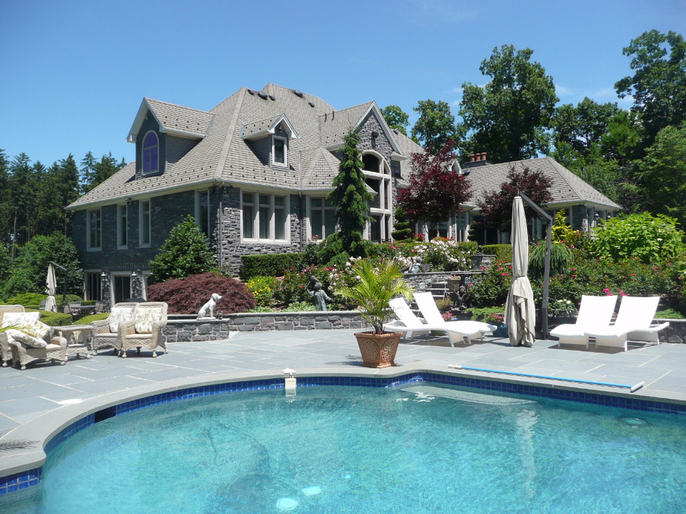 This is an example of a large traditional side yard custom-shaped aboveground pool in New York with tile.