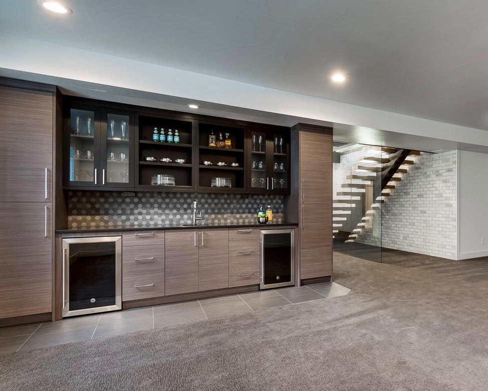 Photo of a mid-sized contemporary single-wall wet bar in Denver with an undermount sink, flat-panel cabinets, granite benchtops, stone tile splashback, porcelain floors, grey floor and black benchtop.