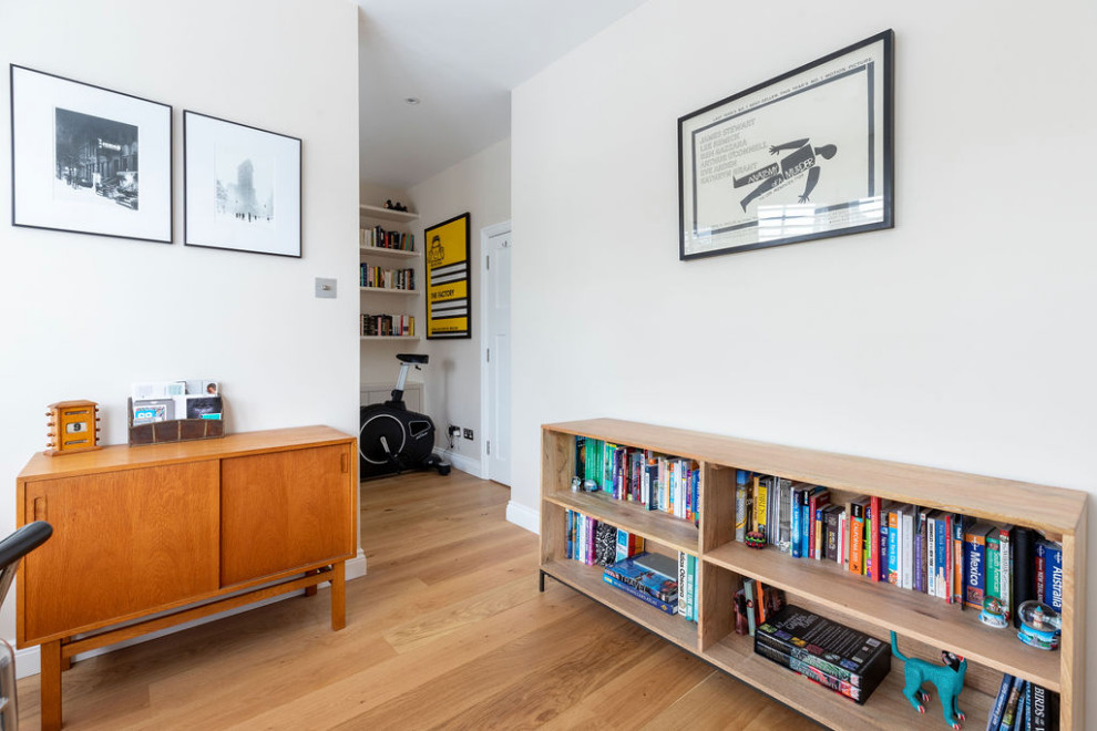 Ejemplo de despacho moderno de tamaño medio con paredes blancas, suelo de madera en tonos medios, escritorio independiente y suelo marrón