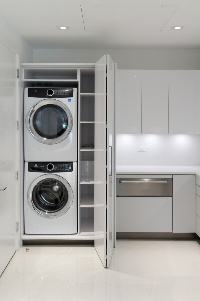 Mid-sized contemporary l-shaped laundry room in Miami with an undermount sink, flat-panel cabinets, grey cabinets, quartz benchtops, white splashback, engineered quartz splashback, ceramic floors, white floor and white benchtop.
