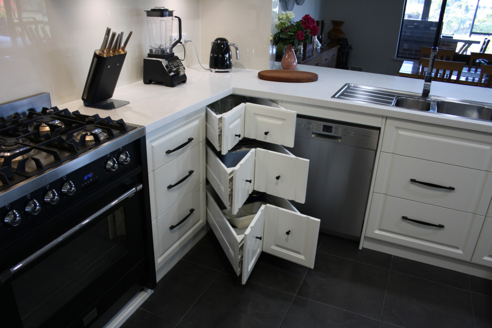 Large traditional u-shaped kitchen in Other with white cabinets, quartz benchtops, white splashback and white benchtop.