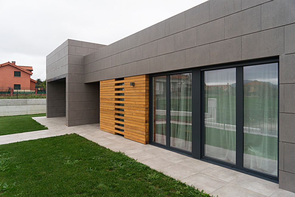 Foto de fachada de casa gris minimalista pequeña de dos plantas con revestimientos combinados, tejado plano y tejado de varios materiales