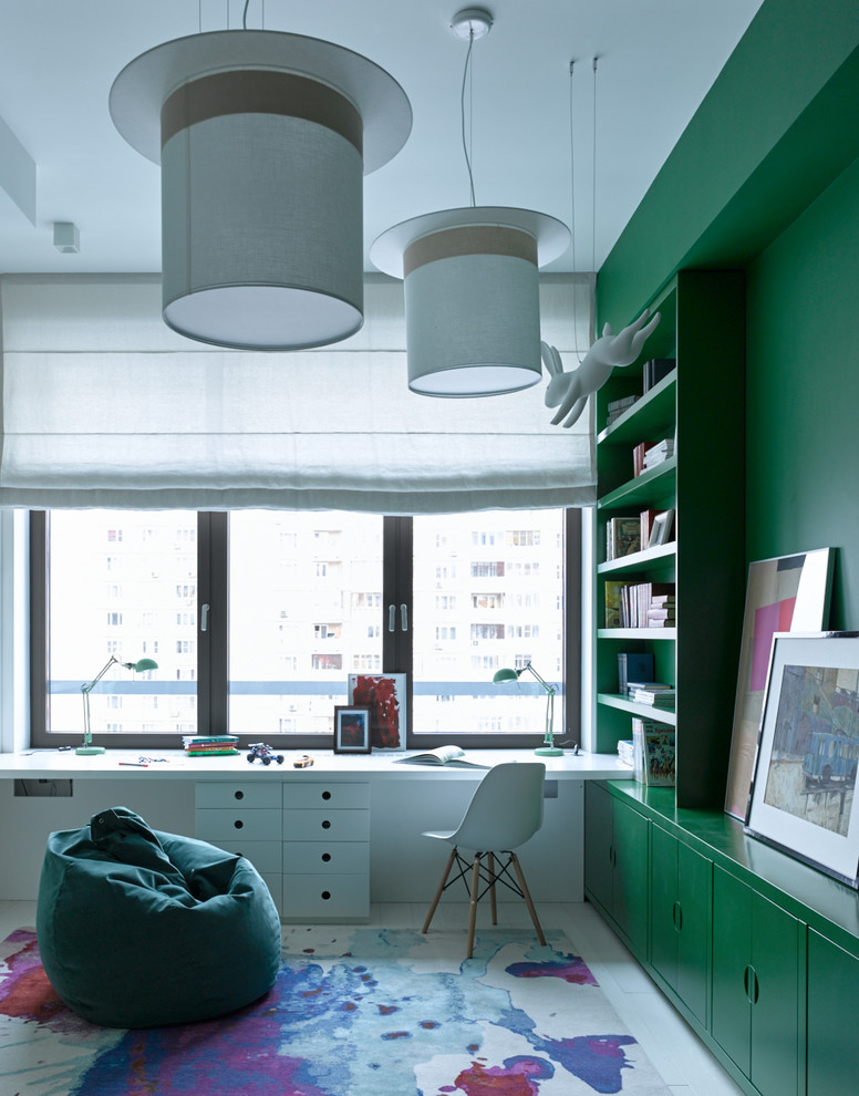 This is an example of a contemporary gender-neutral kids' study room in Moscow with light hardwood floors, white floor and green walls.