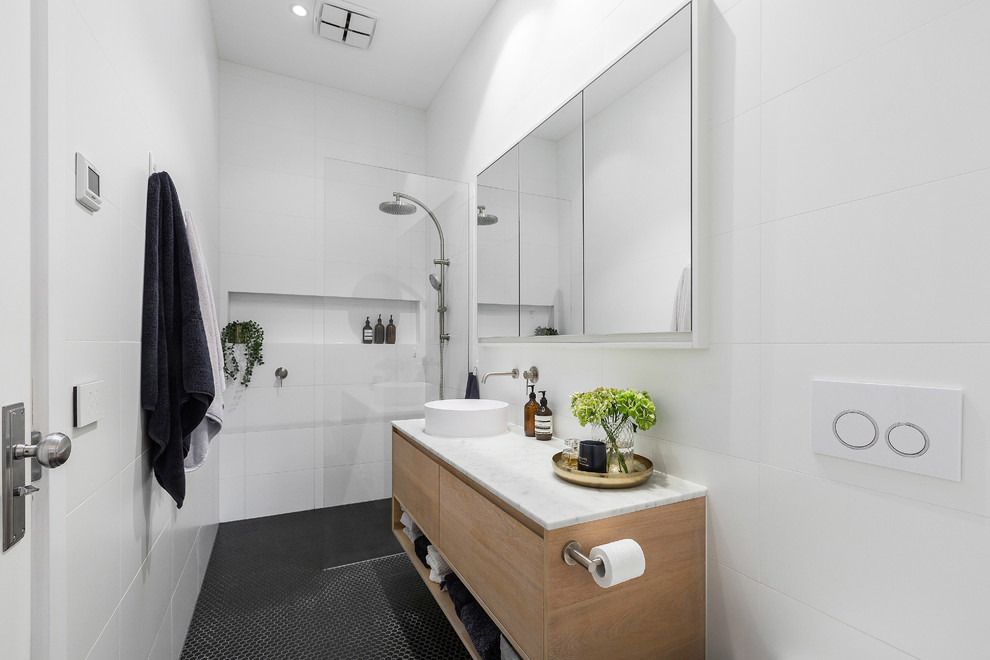 Inspiration for a mid-sized contemporary kids wet room bathroom in Melbourne with light wood cabinets, white tile, porcelain tile, white walls, mosaic tile floors, marble benchtops, black floor, an open shower and white benchtops.