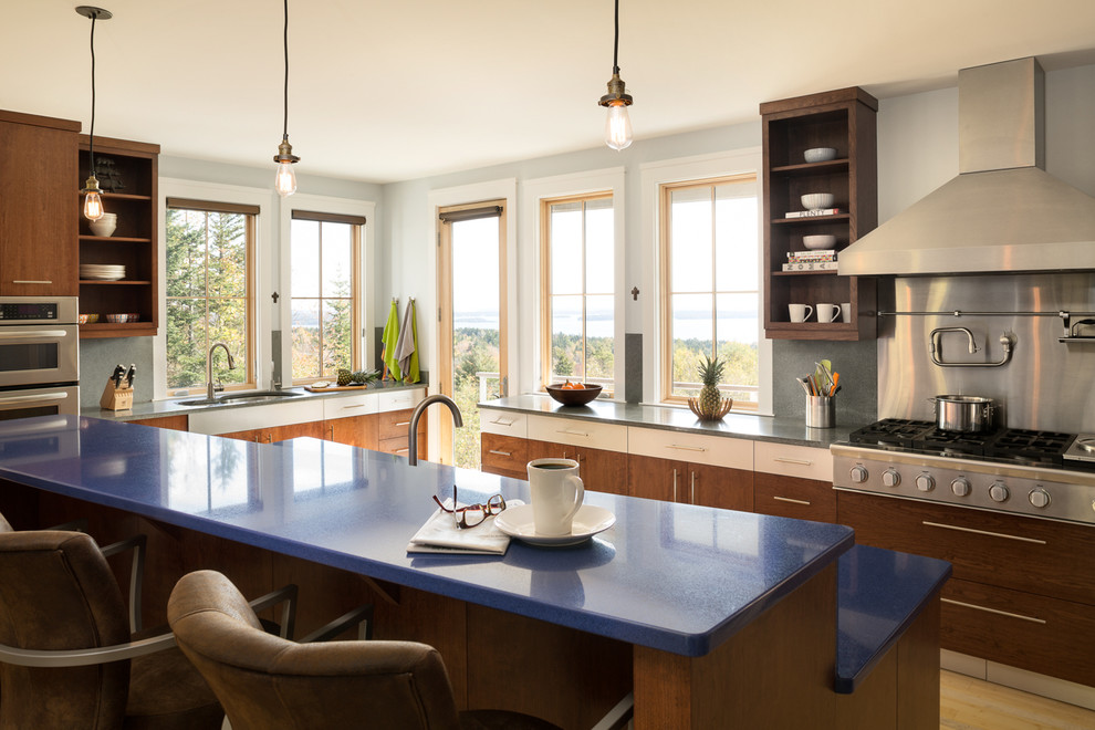 Photo of a transitional kitchen in Portland Maine with an undermount sink, flat-panel cabinets, dark wood cabinets, grey splashback, stainless steel appliances and blue benchtop.