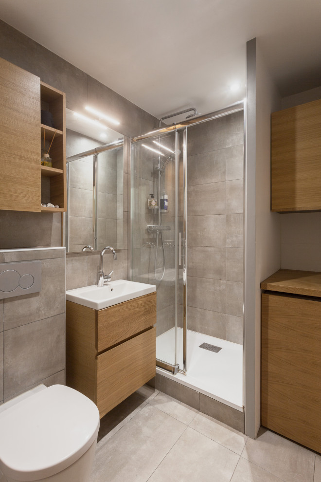 Photo of a mid-sized scandinavian master bathroom in Paris with beaded inset cabinets, light wood cabinets, a wall-mount toilet, beige tile, ceramic tile, white walls, ceramic floors, an undermount sink, wood benchtops, beige floor, a laundry, a single vanity and a floating vanity.