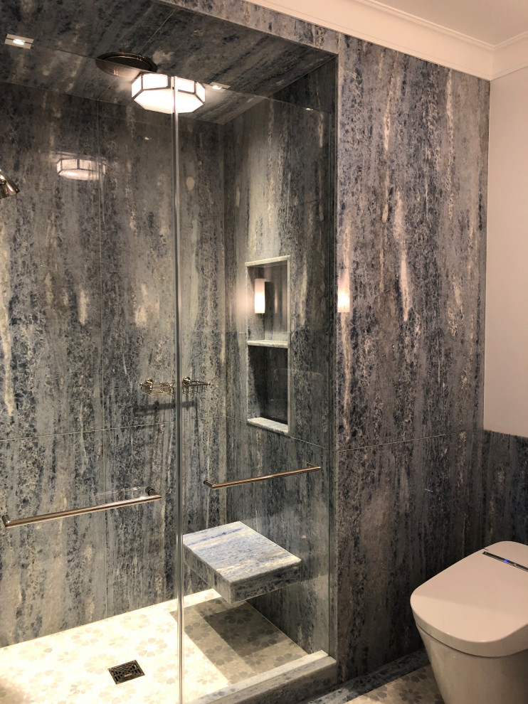 Photo of a mid-sized transitional master bathroom in New York with recessed-panel cabinets, white cabinets, an undermount tub, a shower/bathtub combo, a one-piece toilet, white tile, stone slab, blue walls, mosaic tile floors, an undermount sink, marble benchtops, blue floor, a hinged shower door, white benchtops, a niche, a single vanity, a built-in vanity and decorative wall panelling.