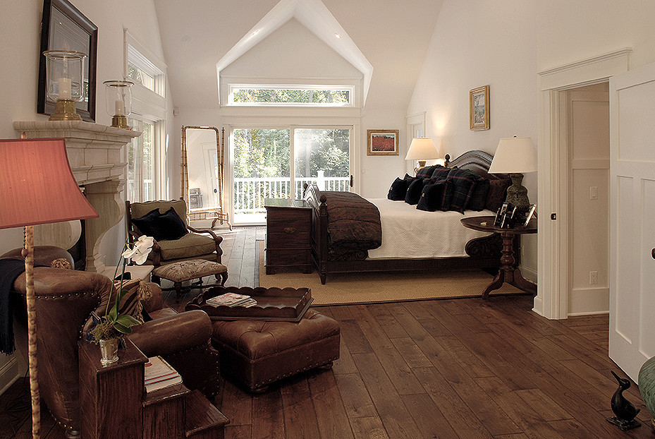 Design ideas for a large traditional master bedroom in Chicago with white walls, dark hardwood floors, a standard fireplace, a stone fireplace surround, brown floor and vaulted.