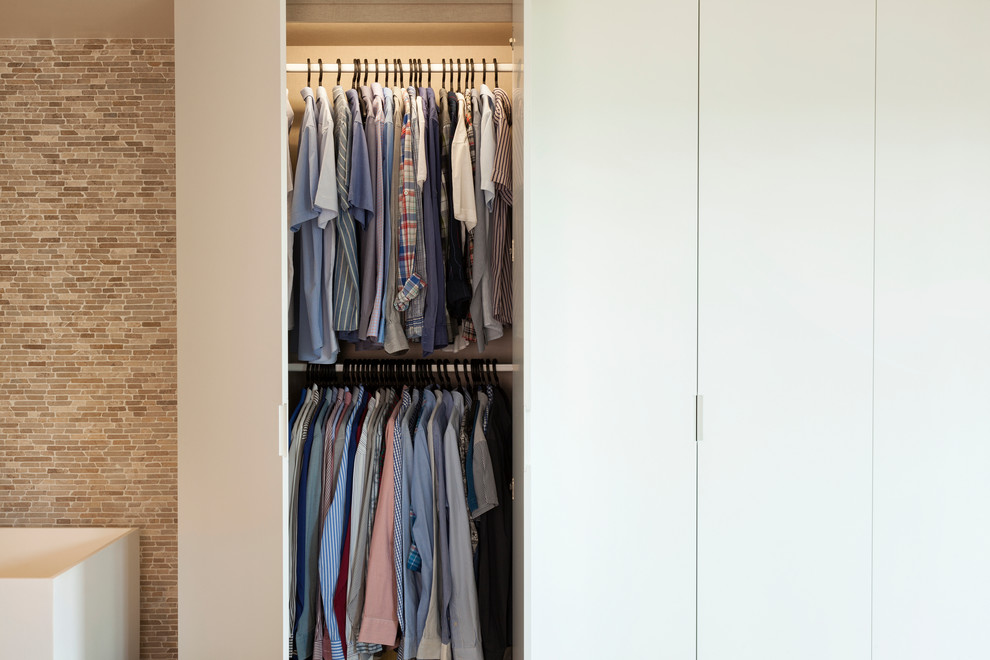 Design ideas for a small modern gender-neutral built-in wardrobe in Paris with white cabinets.