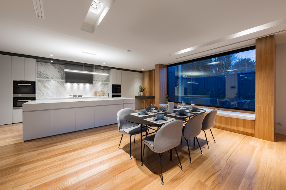 Contemporary open plan dining in Canberra - Queanbeyan with white walls, medium hardwood floors and brown floor.