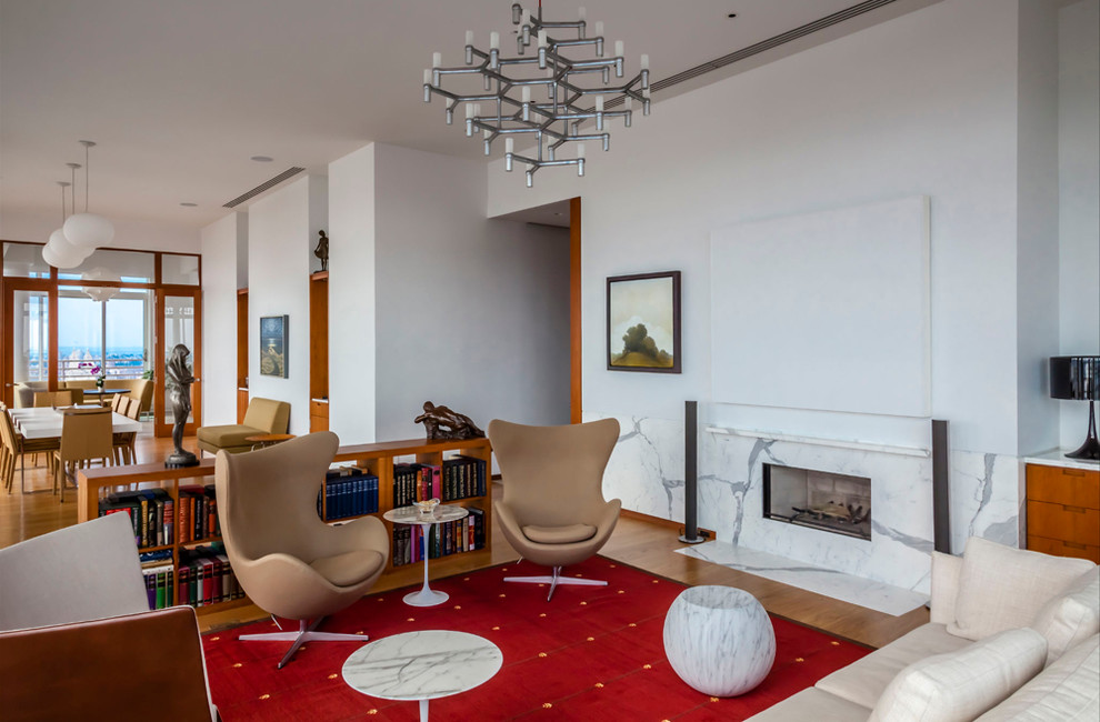 This is an example of a contemporary formal open concept living room in New York with white walls, a ribbon fireplace, a stone fireplace surround and no tv.