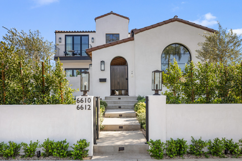 Large and white mediterranean two floor detached house in Los Angeles with a pitched roof, a tiled roof and a brown roof.