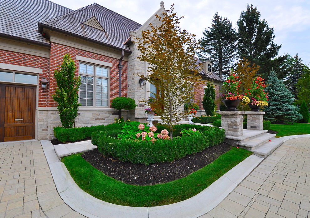 Traditional front yard formal garden in Toronto with brick pavers.