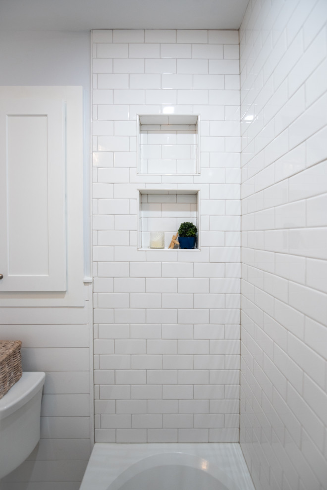 На фото: маленькая главная ванная комната в морском стиле с фасадами в стиле шейкер, белыми фасадами, ванной в нише, душем над ванной, раздельным унитазом, серой плиткой, каменной плиткой, полом из керамической плитки, врезной раковиной, столешницей из искусственного кварца, шторкой для ванной, белой столешницей, нишей, тумбой под одну раковину, встроенной тумбой и стенами из вагонки для на участке и в саду